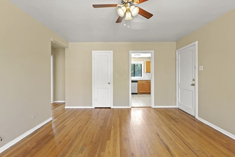 a living room with hardwood floors and a ceiling fan